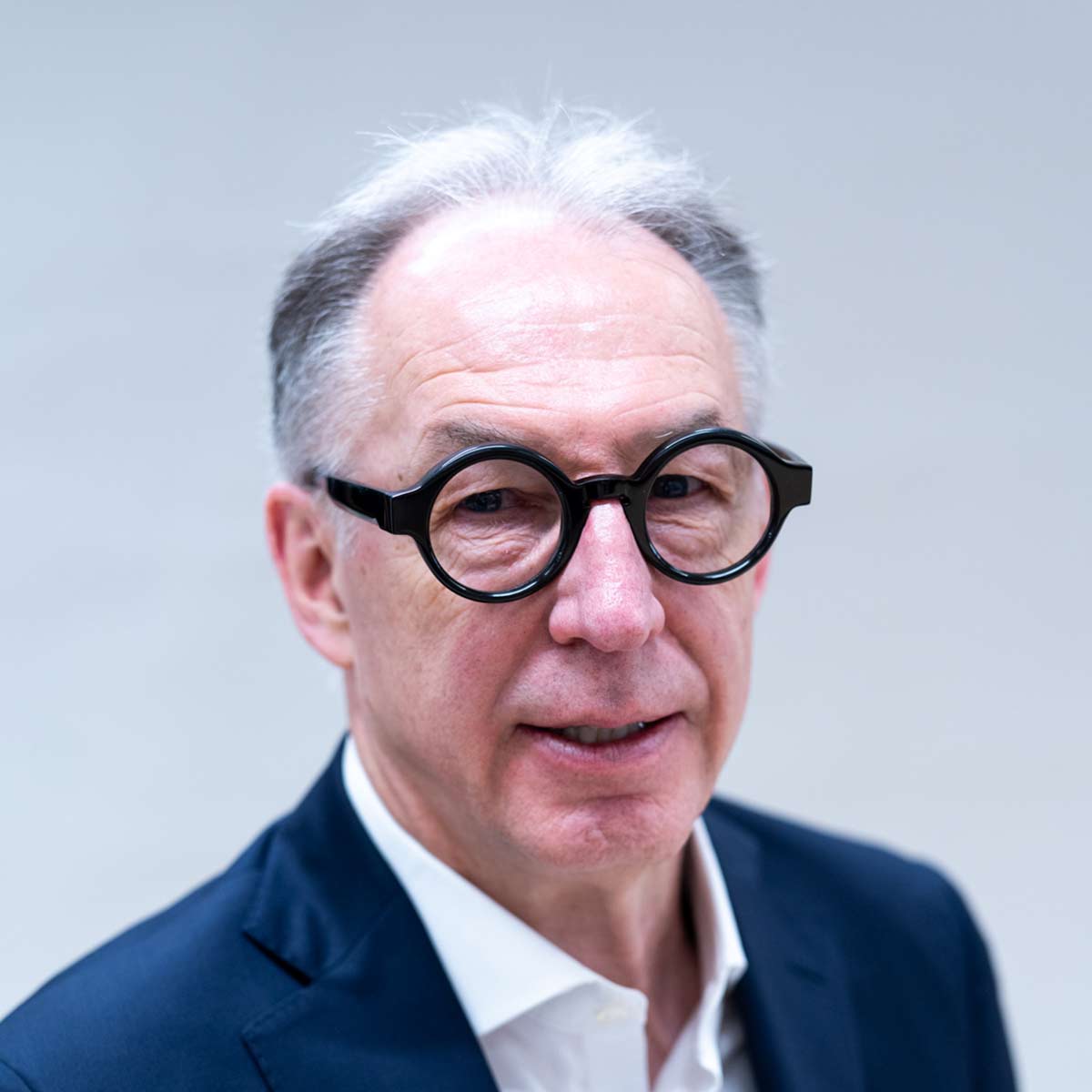 Ein Mann mit Brille sieht in die Kamera